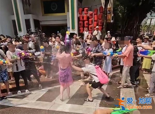 泼水节女游客遭周围人泼水，一男性趁机撕扯雨衣[女游客]？